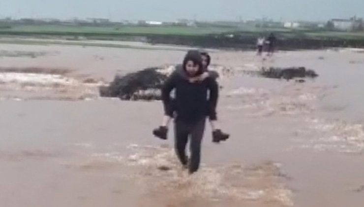 Sağanakta köprü yıkılınca, öğrencileri sırtlarında taşıdılar